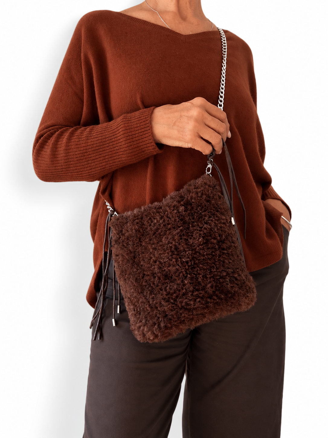 Borsa Astrid marrone indossata crossbody, abbinata a un outfit nei toni caldi del marrone.