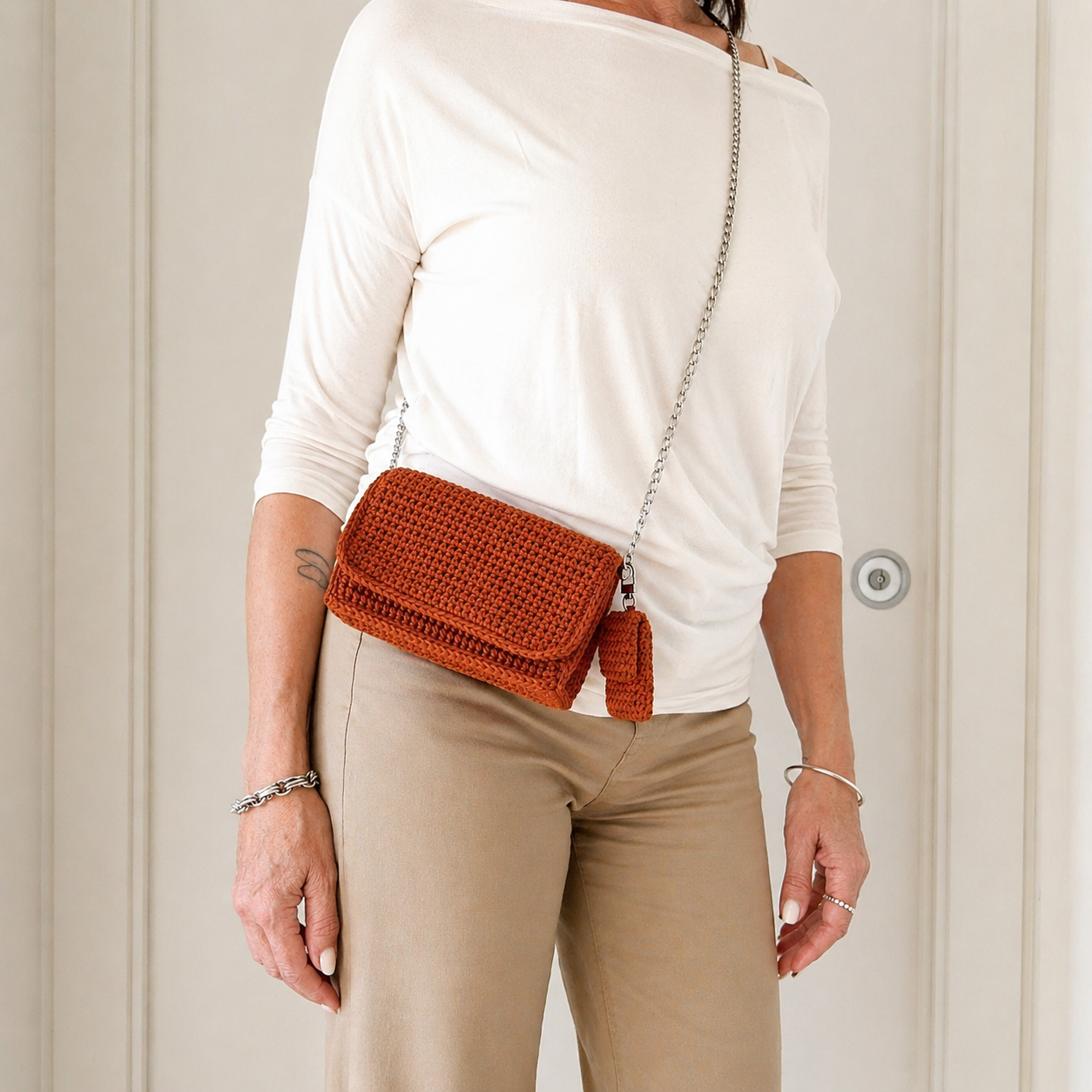 borsa uncinetto elegante Ava arancione con catena argentata indossata vista lato