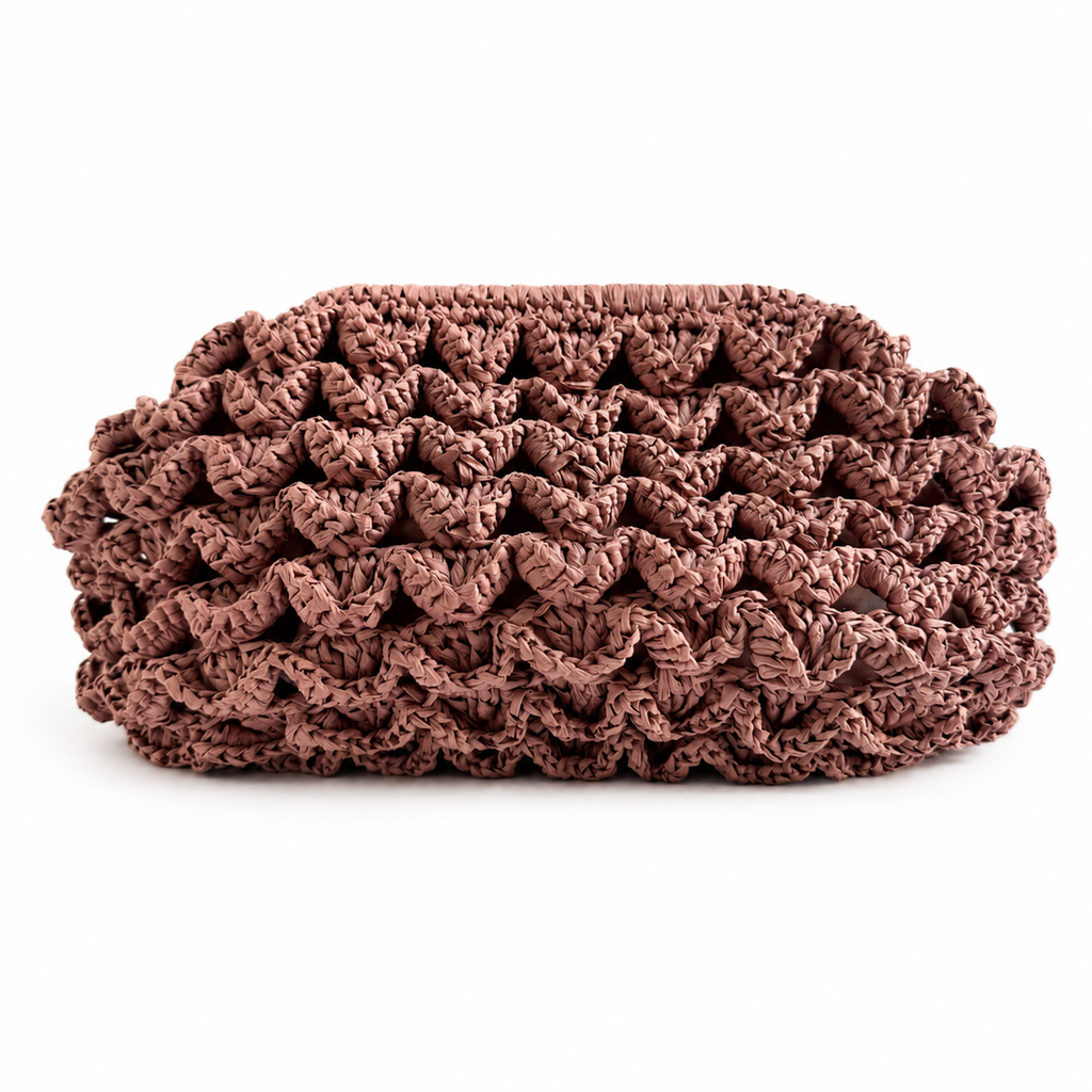 Vista frontale della clutch Duna in rafia rosa con lavorazione tridimensionale all'uncinetto.