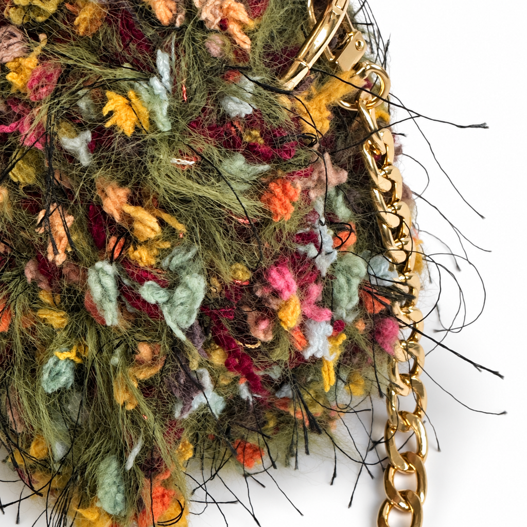 Dettaglio laterale della borsa Elettra all’uncinetto con texture materica e catena dorata