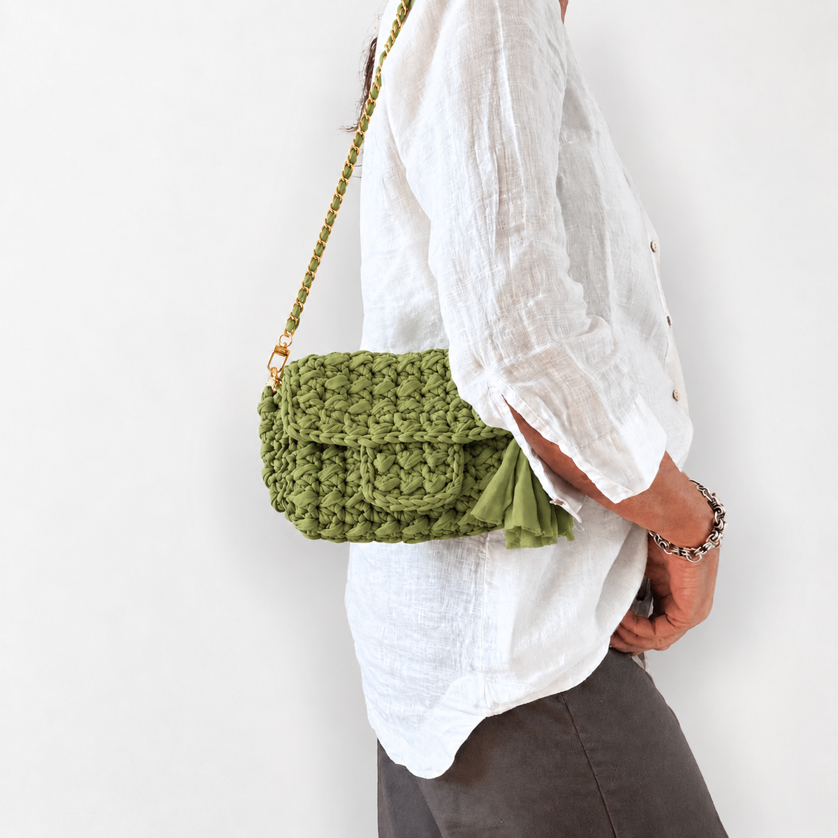 Ella Mini Bag crochet verde oliva indossata a spalla, vista laterale
