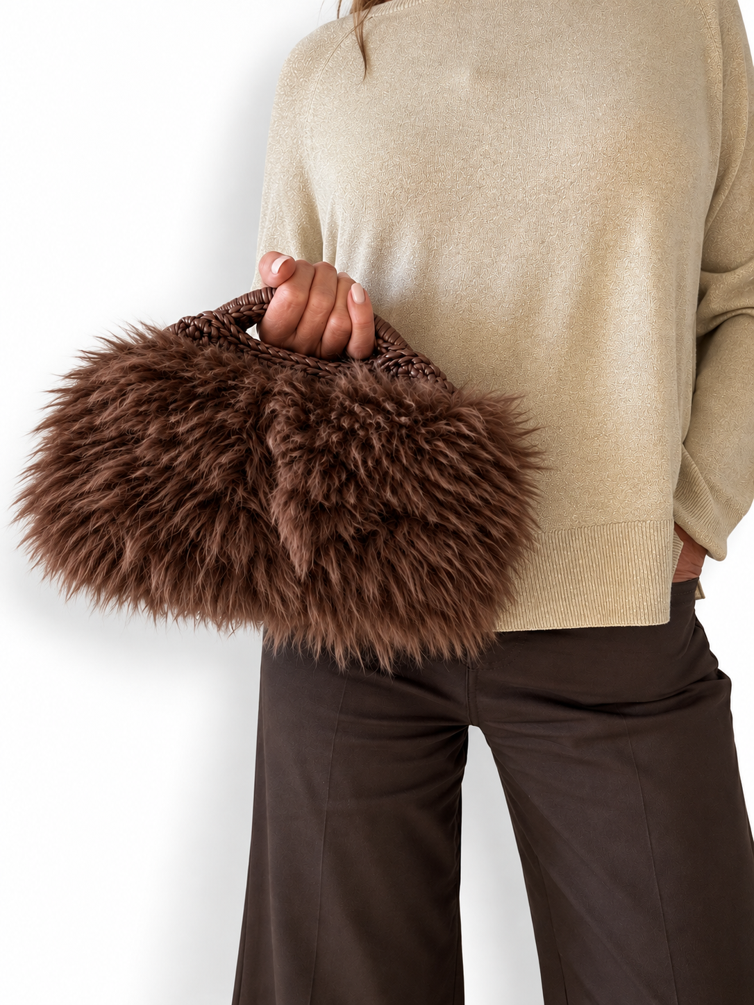 Clutch Greta marrone in ecopelliccia indossata a mano con outfit autunnale nei toni neutri