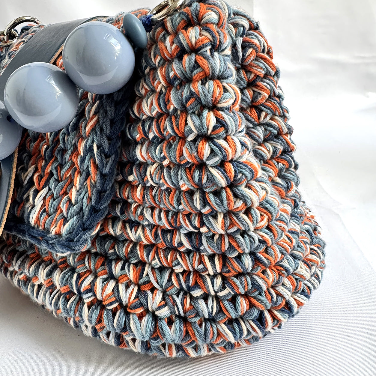 Vista laterale della borsa crochet Kia blu che evidenzia la lavorazione artigianale.