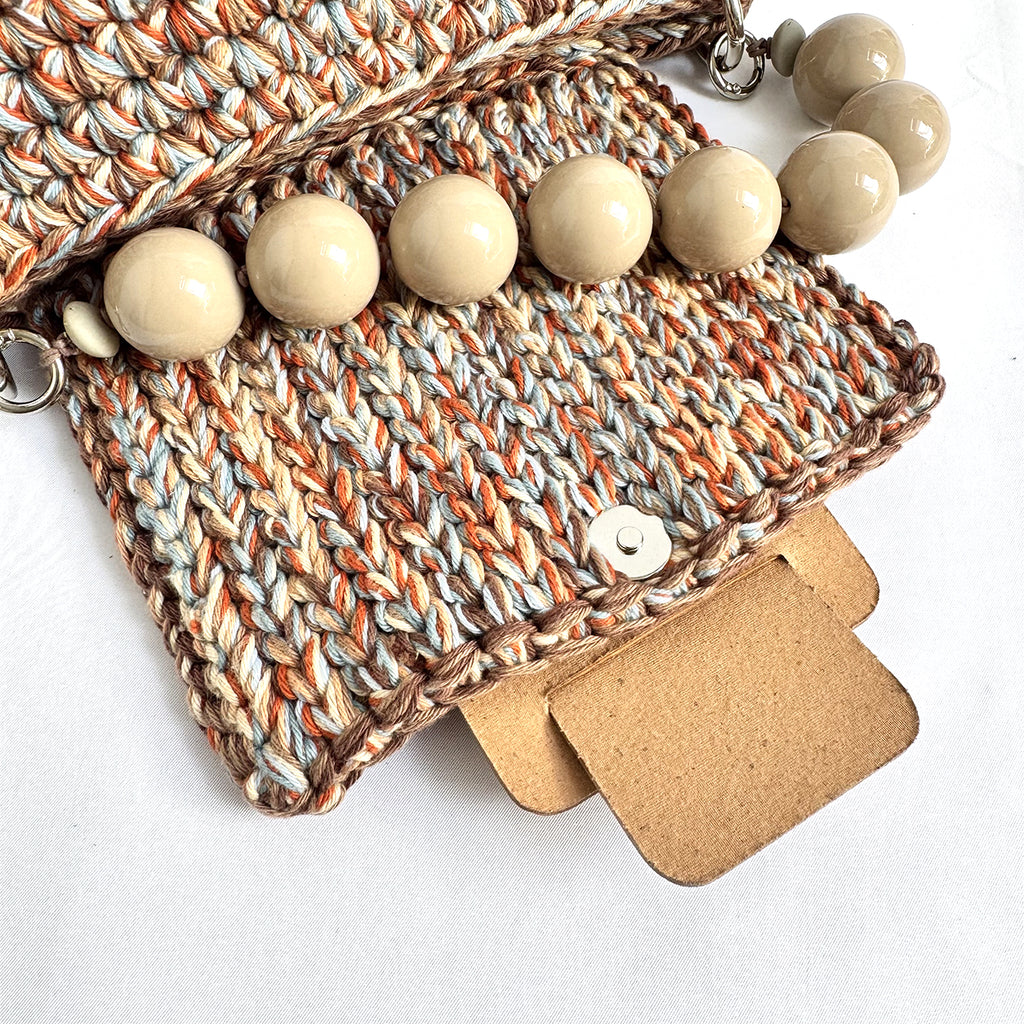Dettaglio del manico con grandi perle della borsa crochet Kia Cuoio Chiaro.