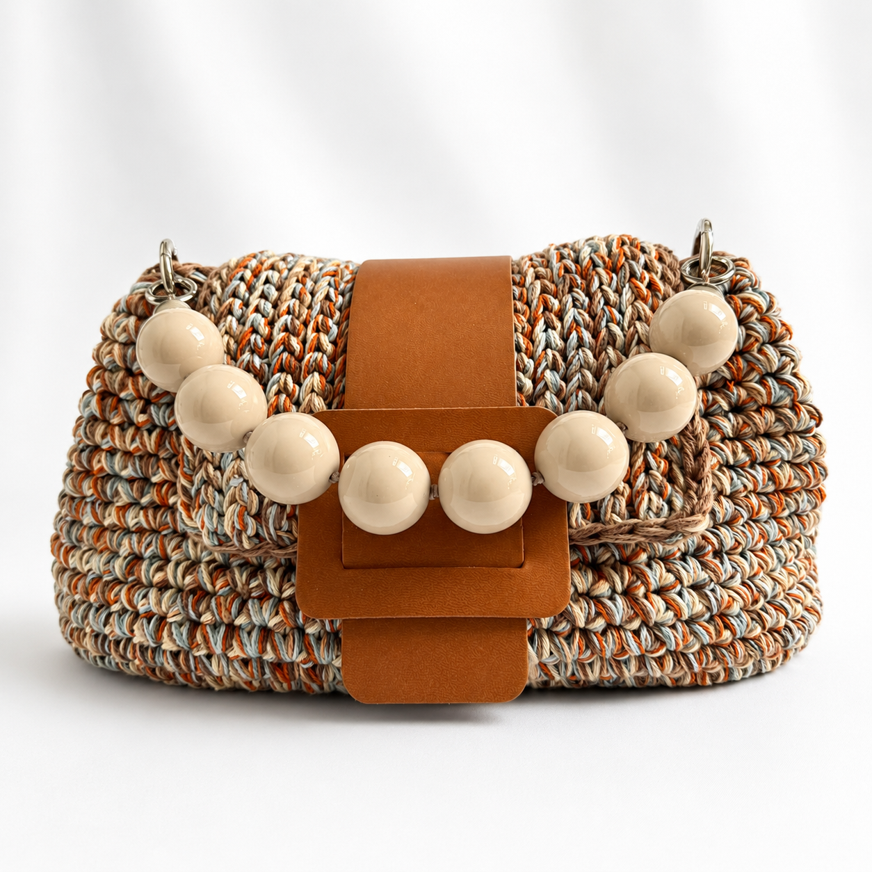 Vista frontale della borsa crochet Kia cuoio chiaro con manico di perle.