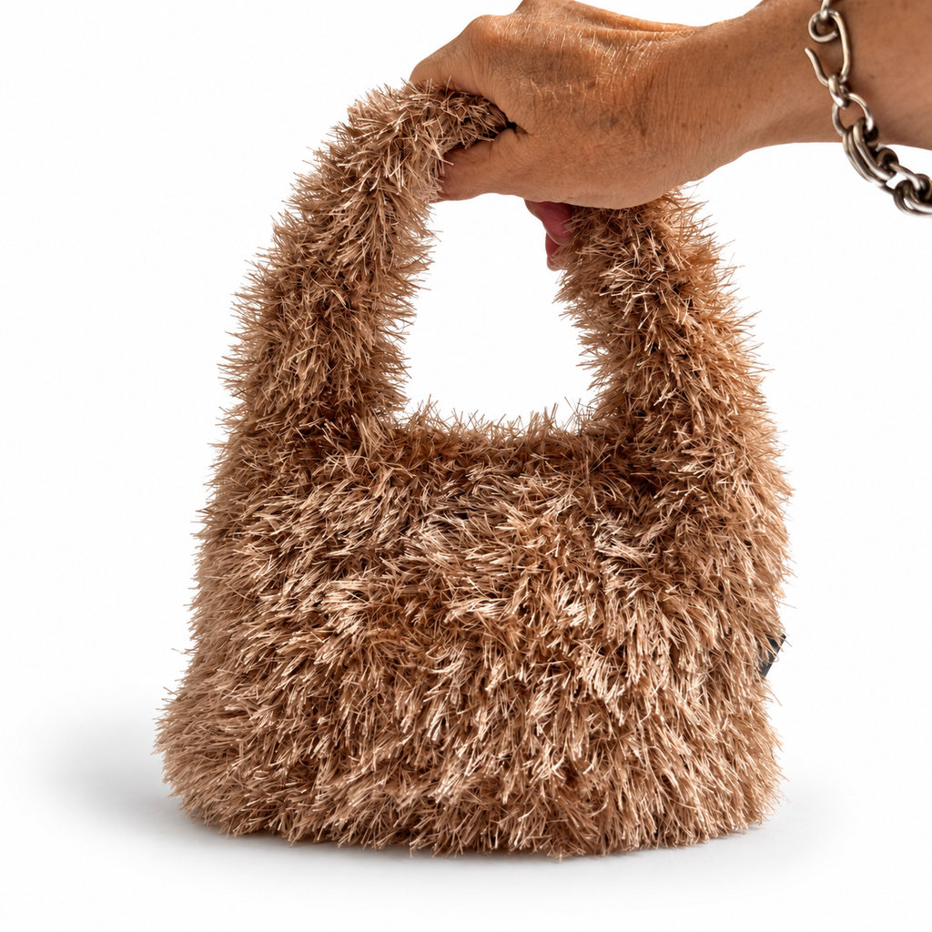 Borsa crochet Lula Fur color caramello tenuta in mano