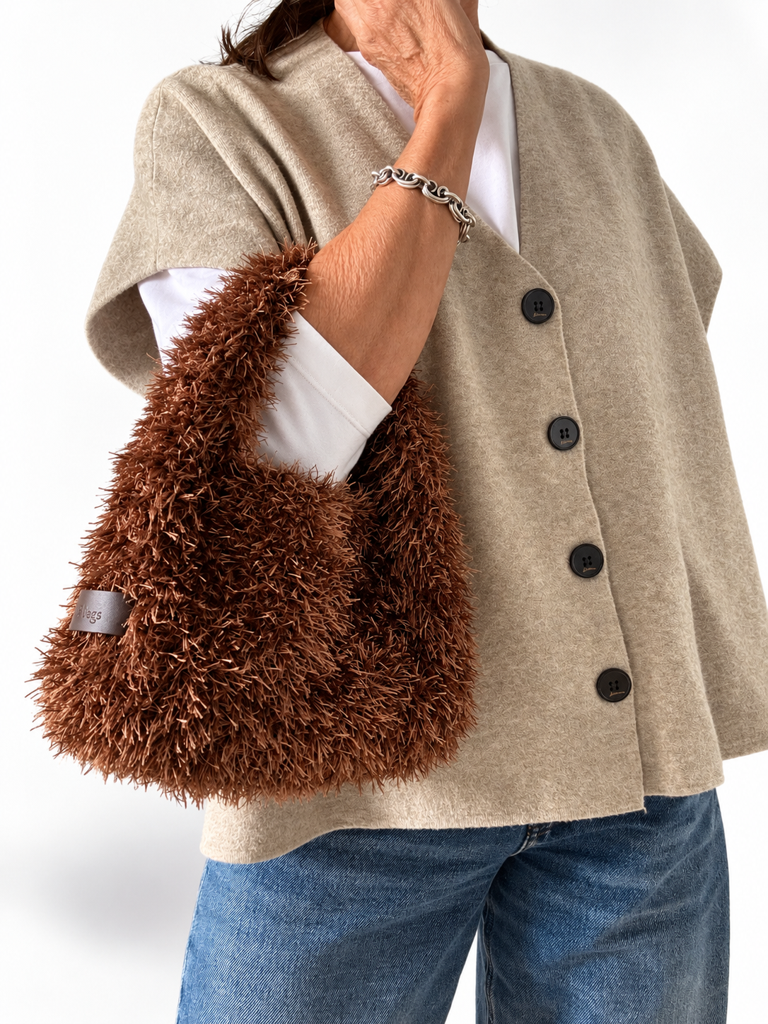 Borsa crochet Lula Fur color tabacco indossata, con manico integrato
