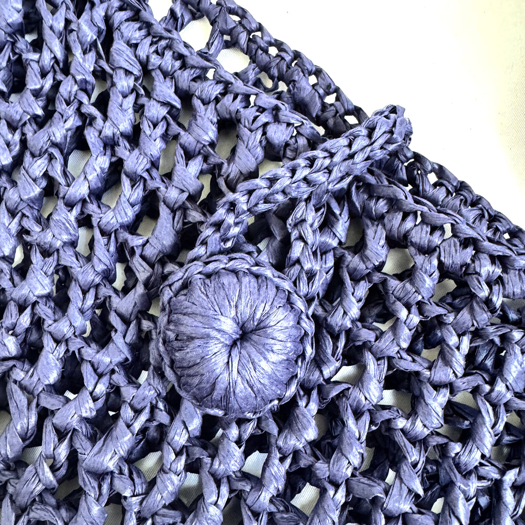 Dettaglio della chiusura artigianale della borsa Maris in rafia blu.
