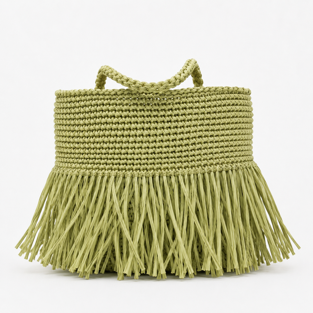 Borsa in rafia verde pistacchio con frange su sfondo bianco