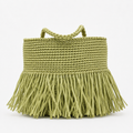 Borsa in rafia verde pistacchio con frange su sfondo bianco