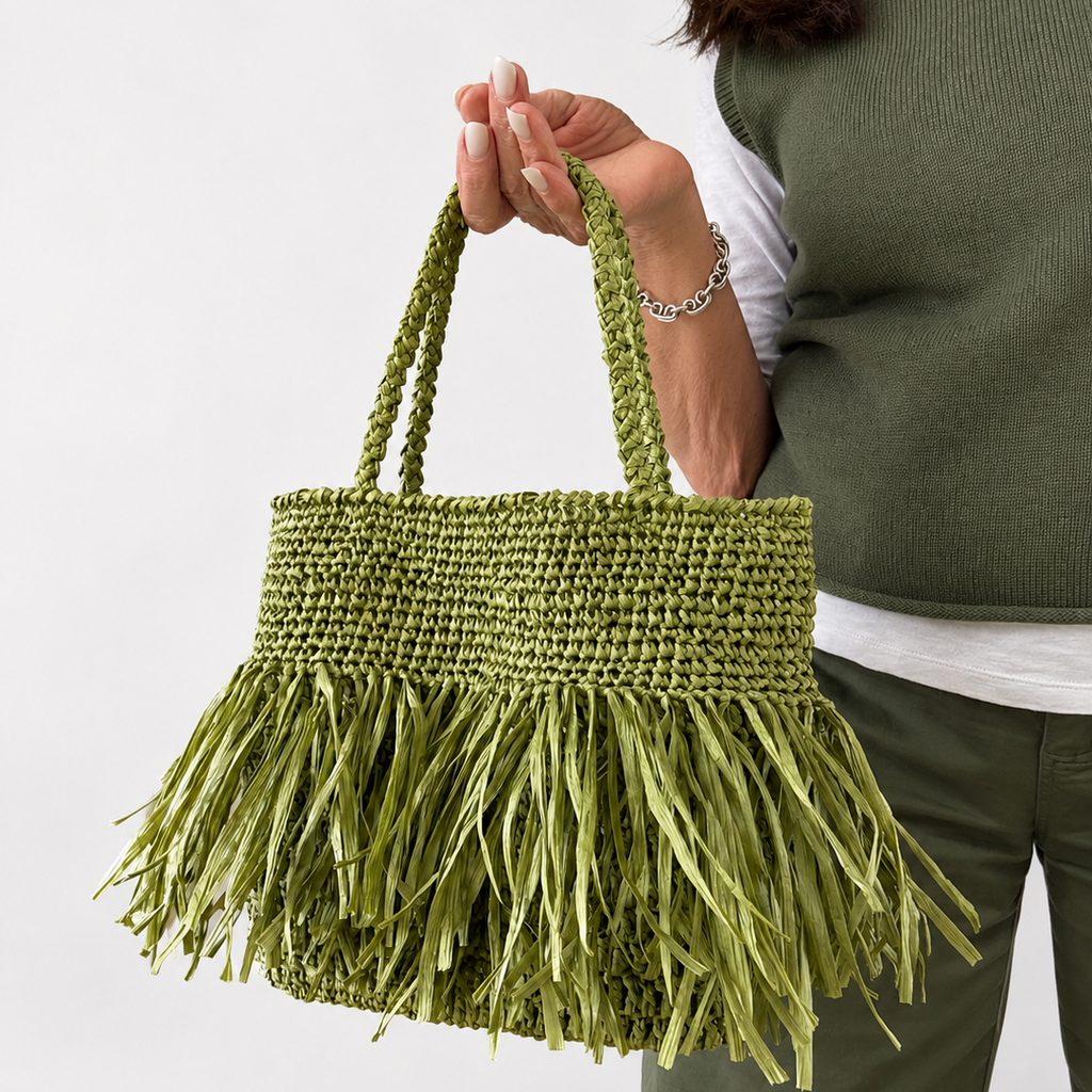 Vista laterale della borsa in rafia verde con frange decorative