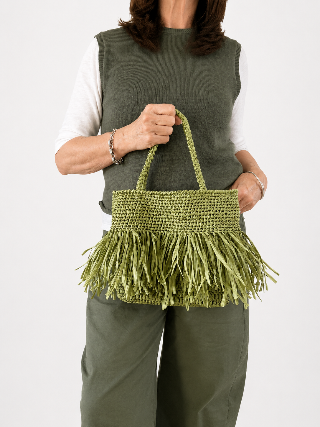 Modella con borsa in rafia verde pistacchio fatta a mano