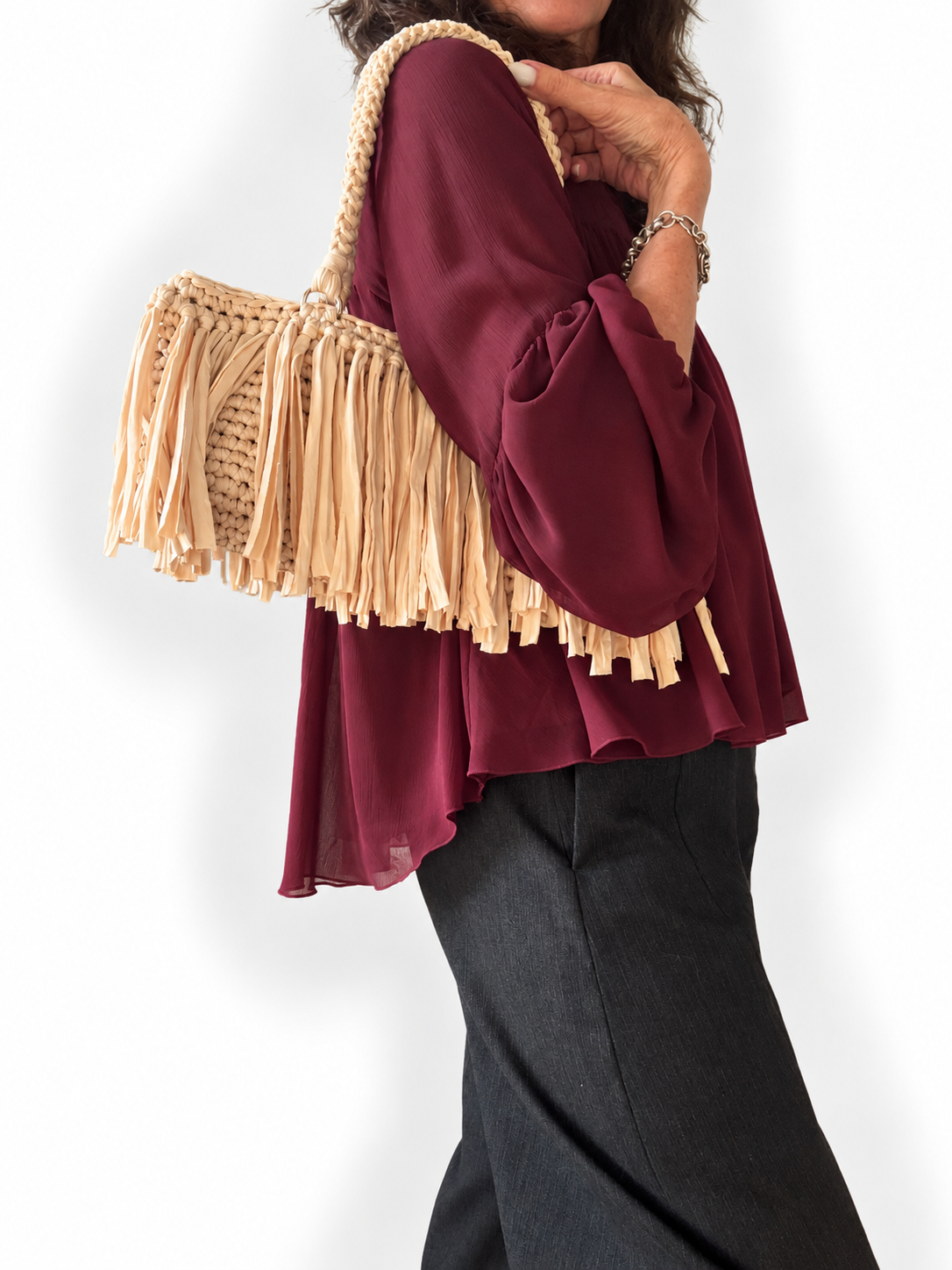 Borsa Sienna color crema indossata a spalla con frange in movimento
